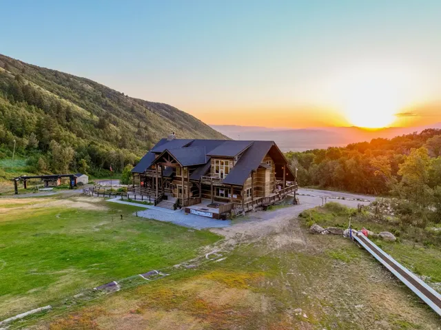 Expansive mountain property featuring a multi-level structure with natural wood siding and a dark roof