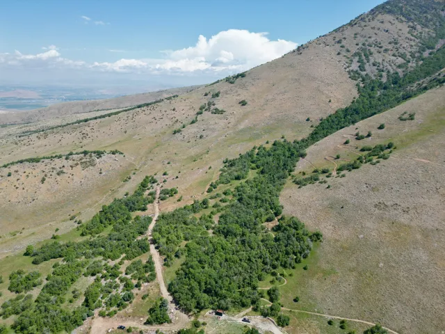 Expansive mountain terrain featuring natural vegetation and distant landscape
