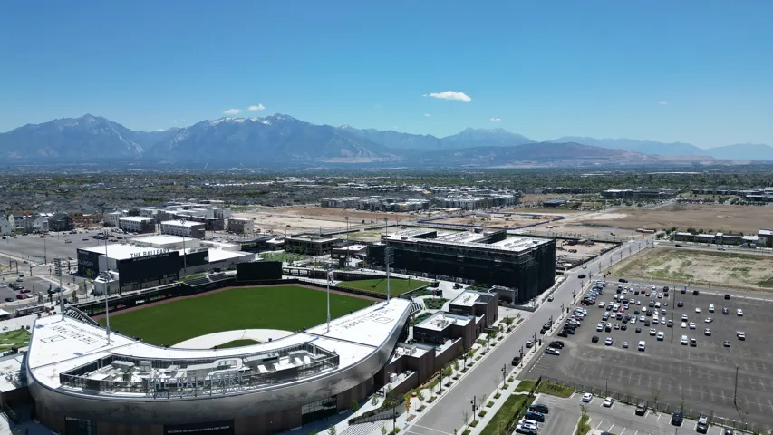 Aerial perspective showcasing a baseball stadium with a green field and surrounding buildings