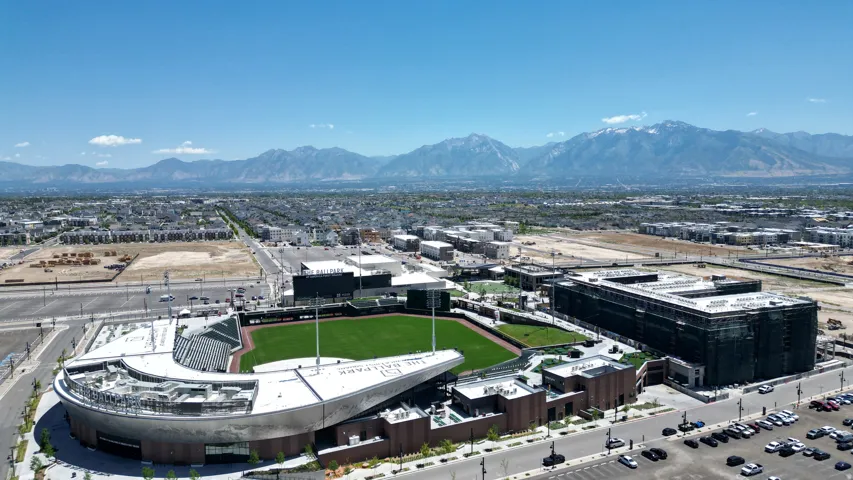 Aerial perspective showcasing a sports stadium with a green field and surrounding structures