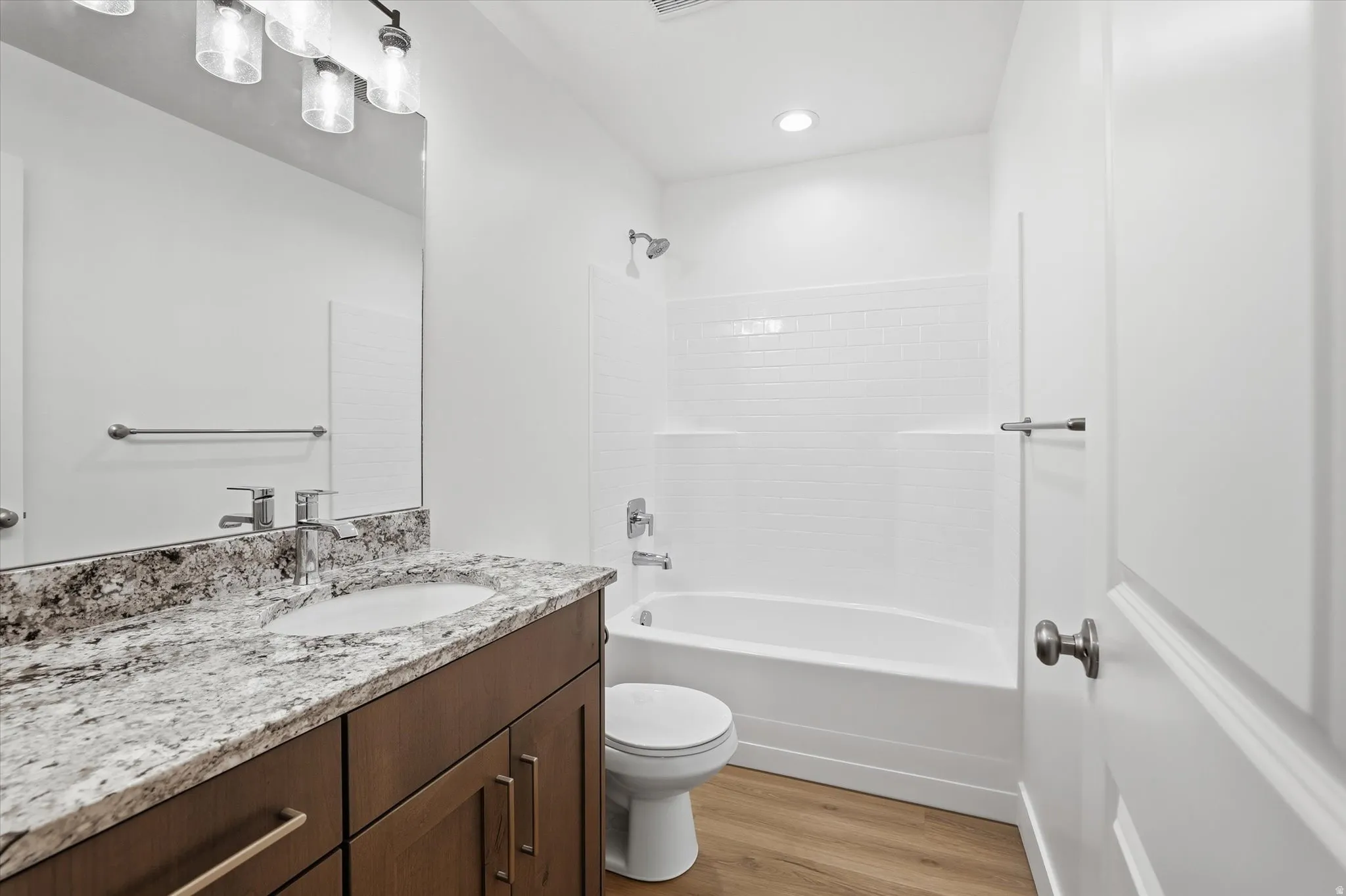 Bathroom vanity featuring a light-toned stone countertop, integrated sink, and dark wood-finish cabinetry