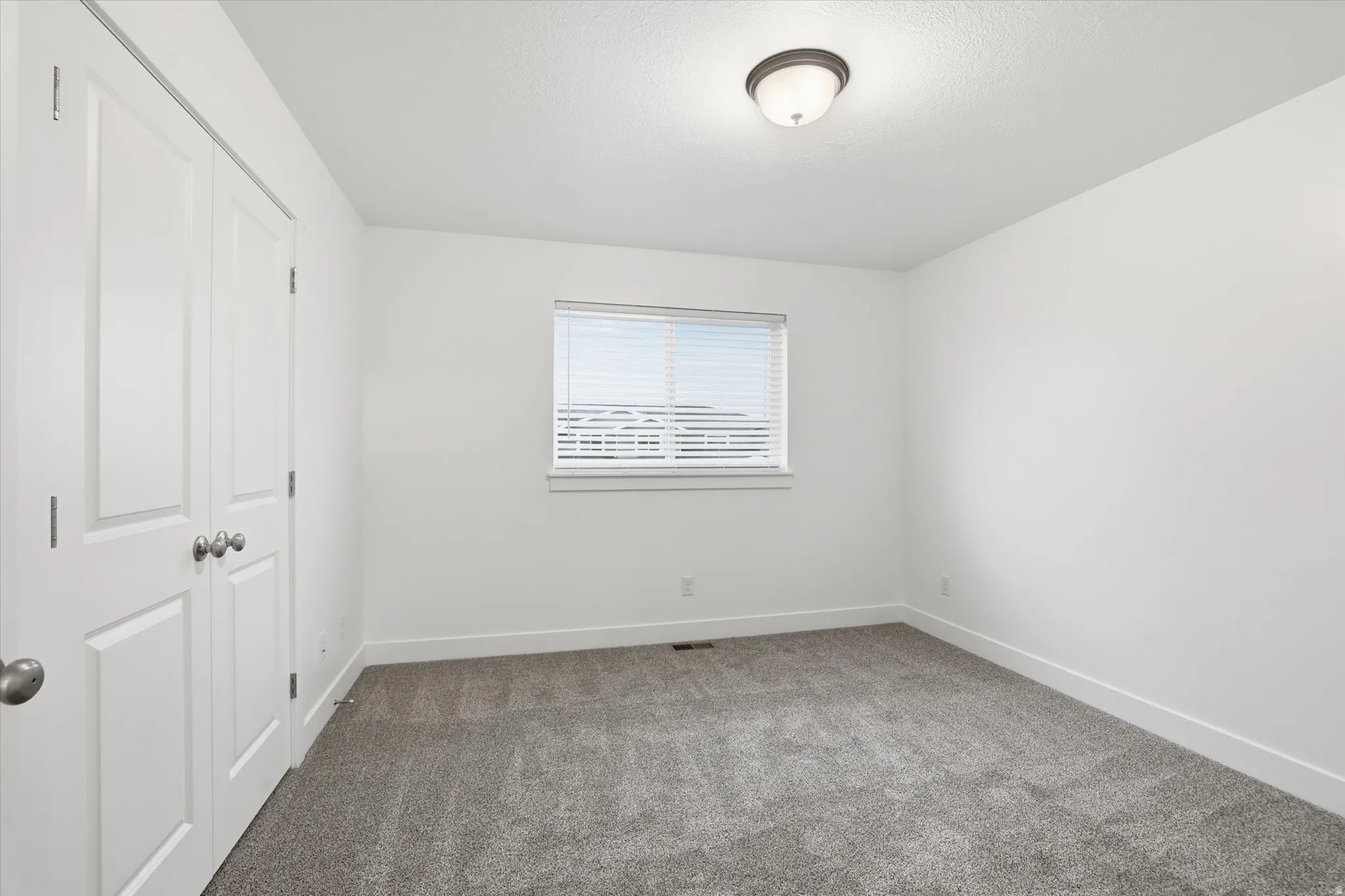 Room featuring neutral wall finishes and grey carpet flooring