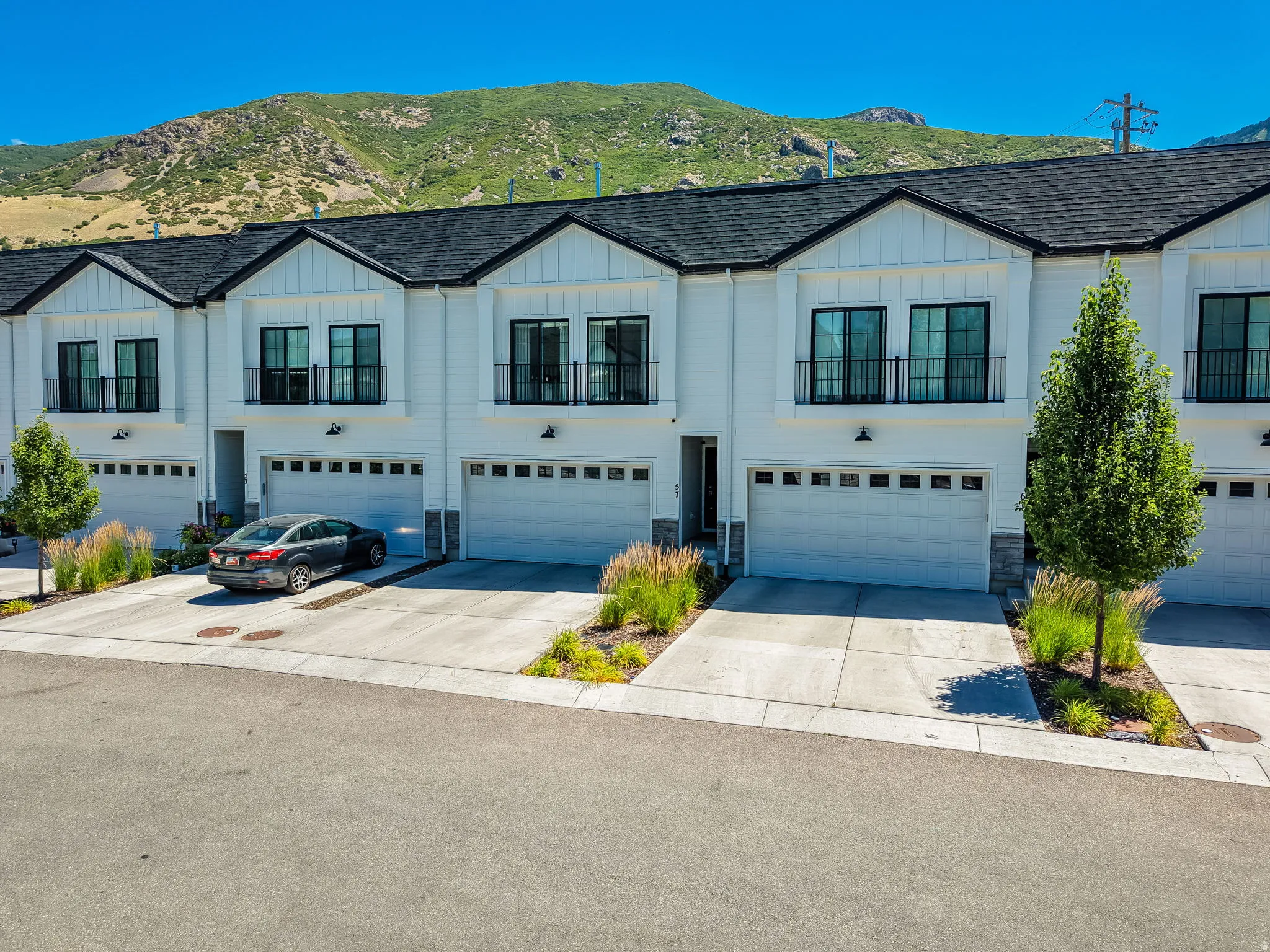 Modern townhome exteriors featuring white siding and black-framed windows