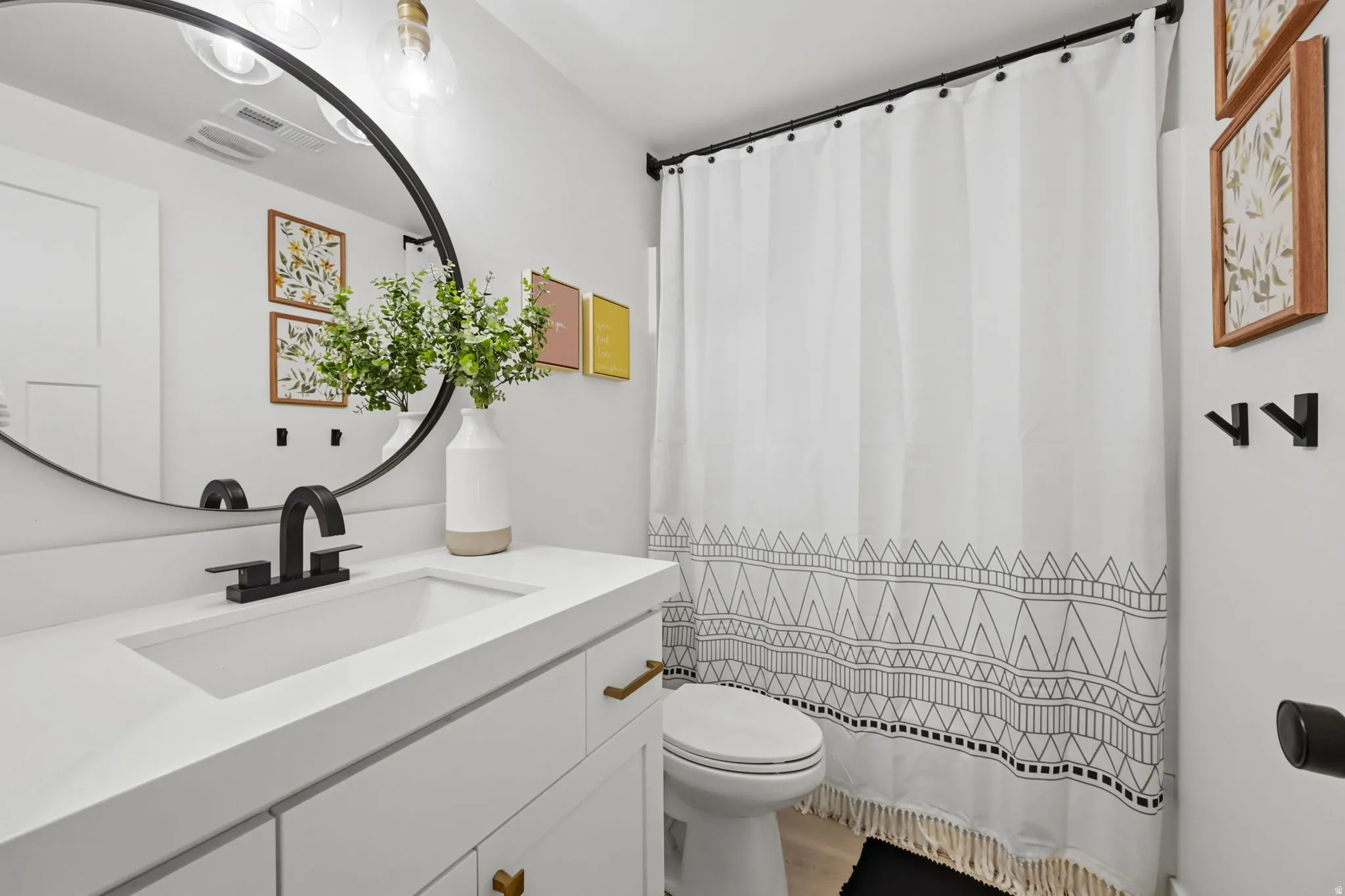 Modern bathroom featuring a white vanity with brass-tone hardware and an integrated sink