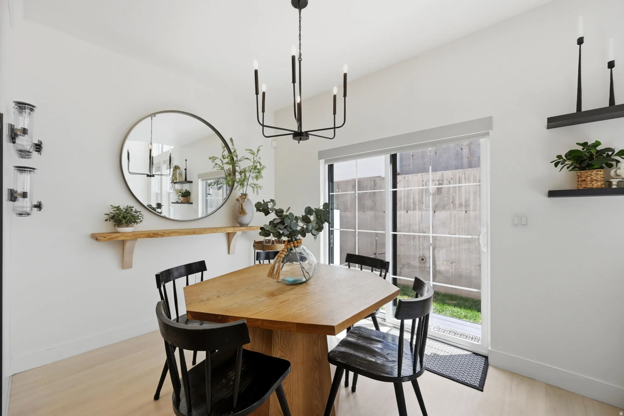Dining area featuring a modern black chandelier, and a sliding glass door