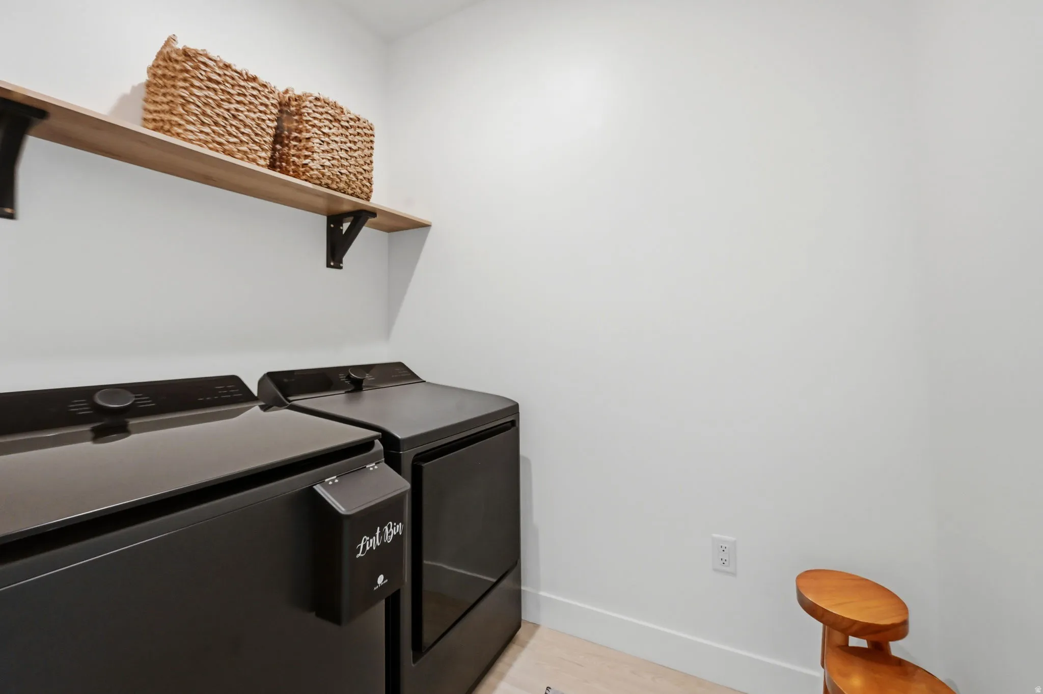Dedicated laundry area featuring a wood-finish floating shelf