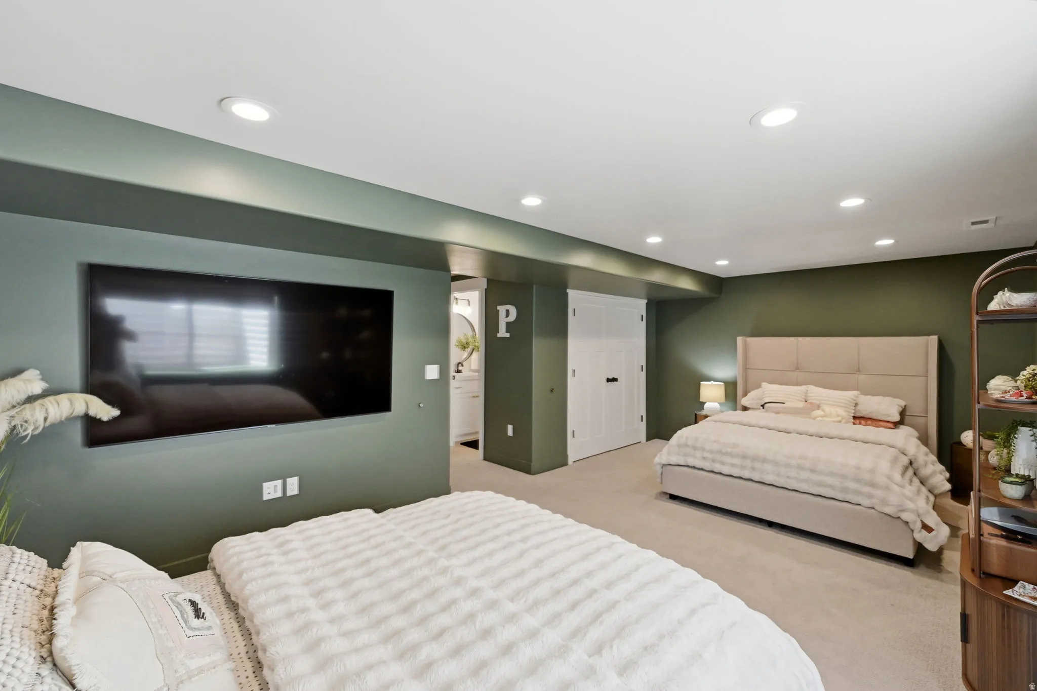 Spacious room featuring recessed lighting, a neutral carpeted floor, and two sets of white bifold closet doors