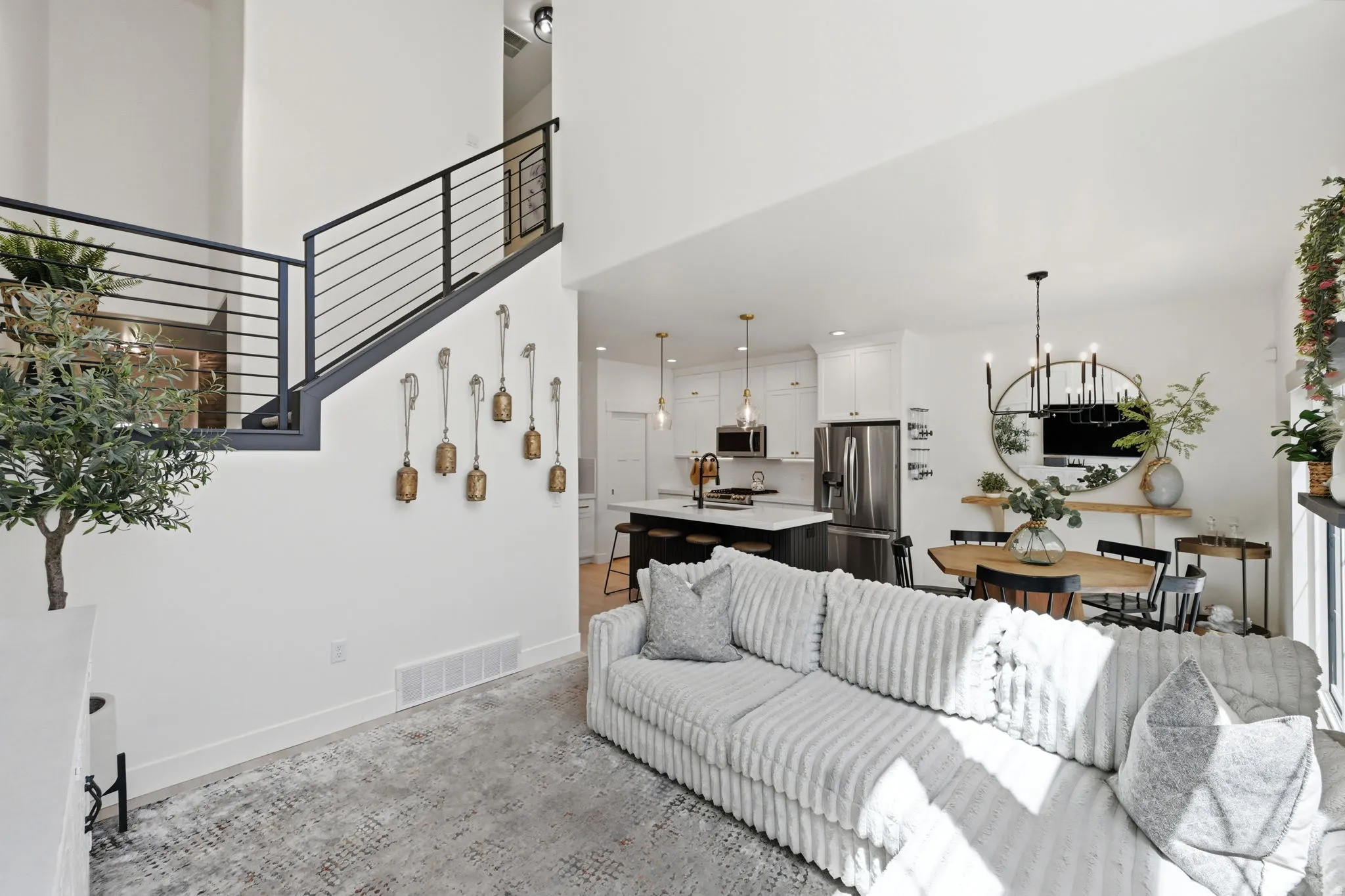 Open-concept living space with high ceilings and a modern iron stair railing