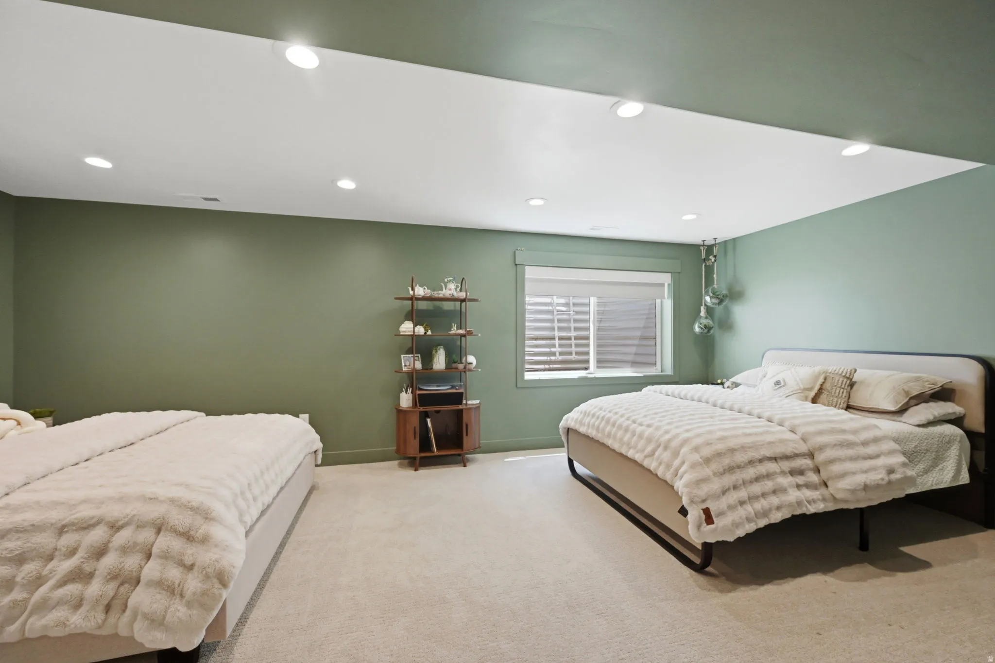 Spacious room may be family room featuring muted green walls and a recessed ceiling with integrated lighting