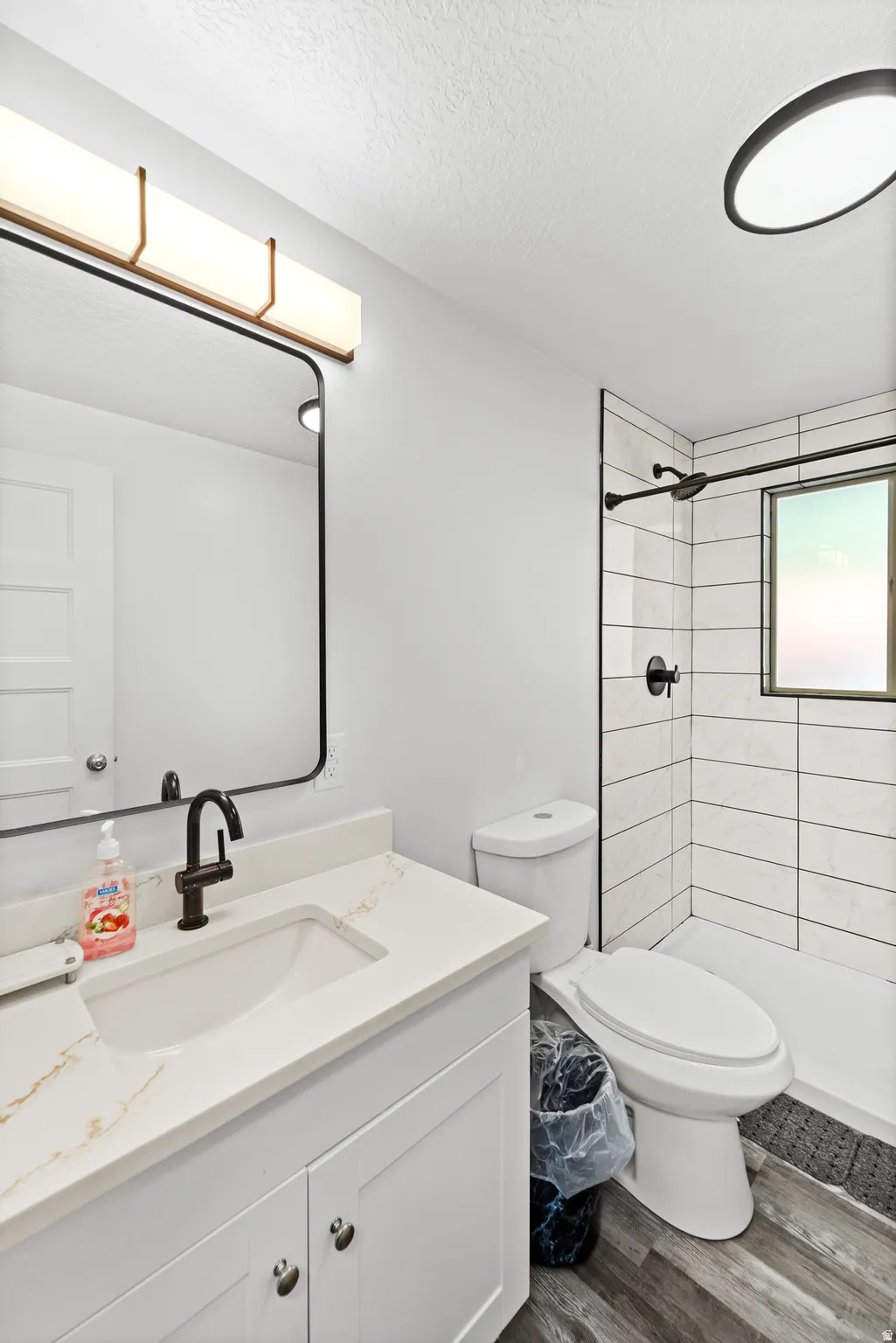Bathroom featuring a white vanity with a light-colored countertop, an undermount sink, and a black faucet