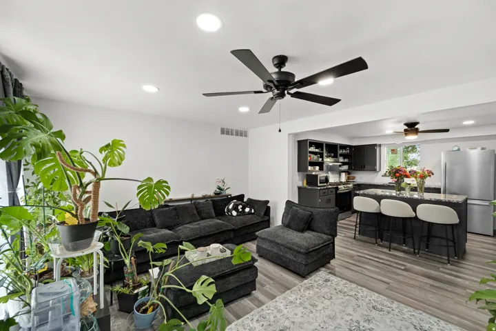 Open-concept living space featuring wood-finish flooring, recessed lighting, and a contemporary ceiling fan