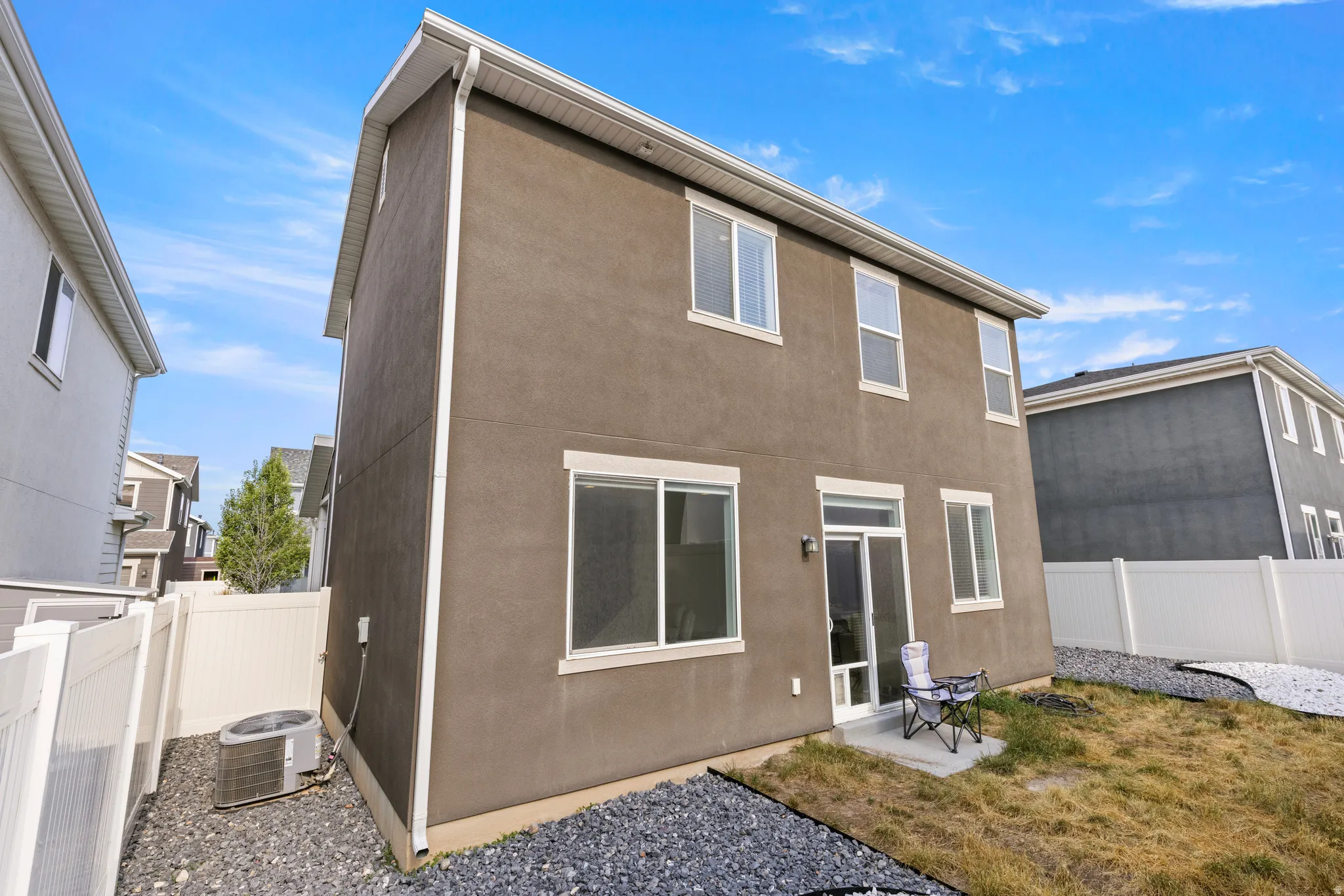 Two-story stucco exterior with white trim and multiple windows