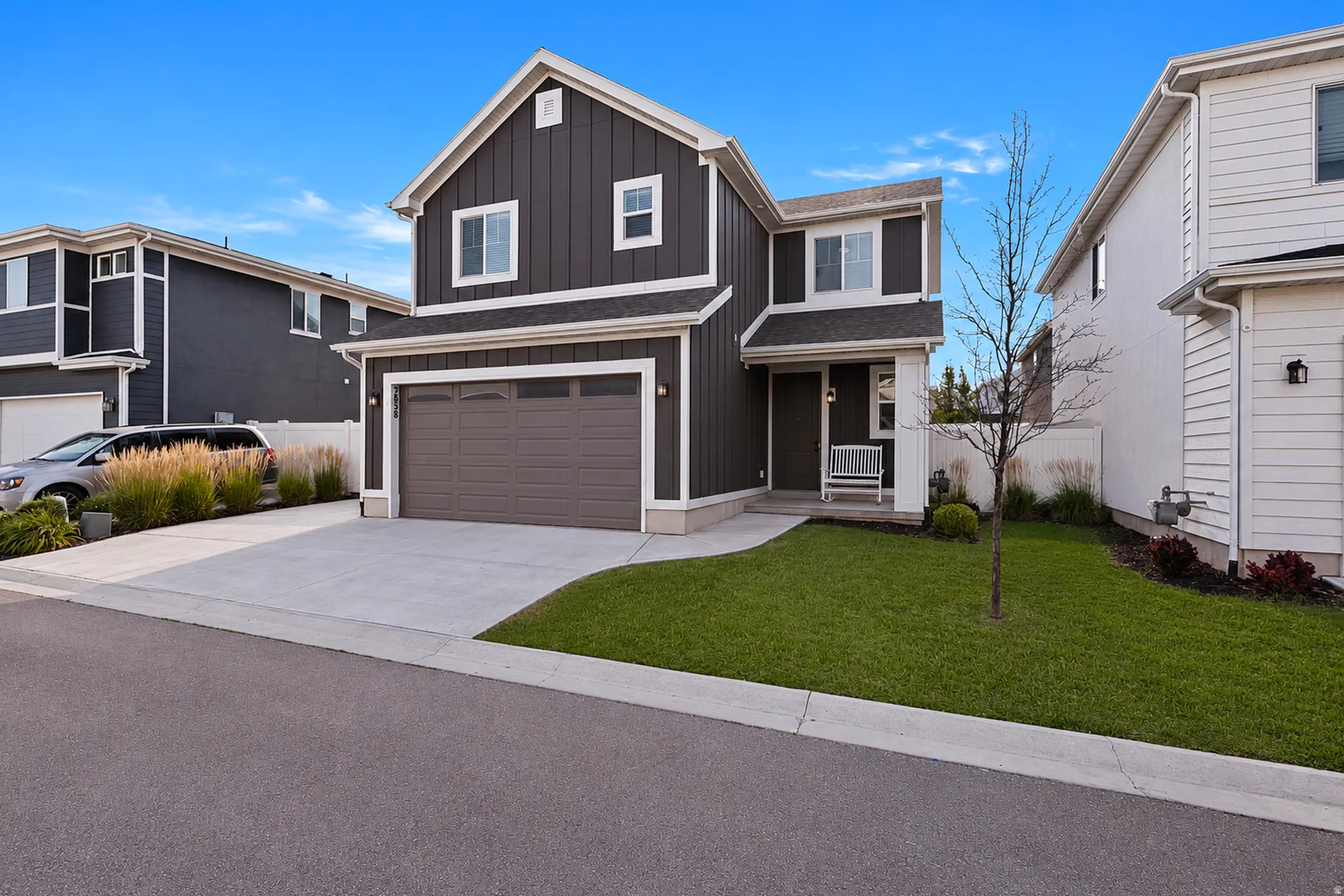 Modern two-story residence featuring dark vertical siding and white trim