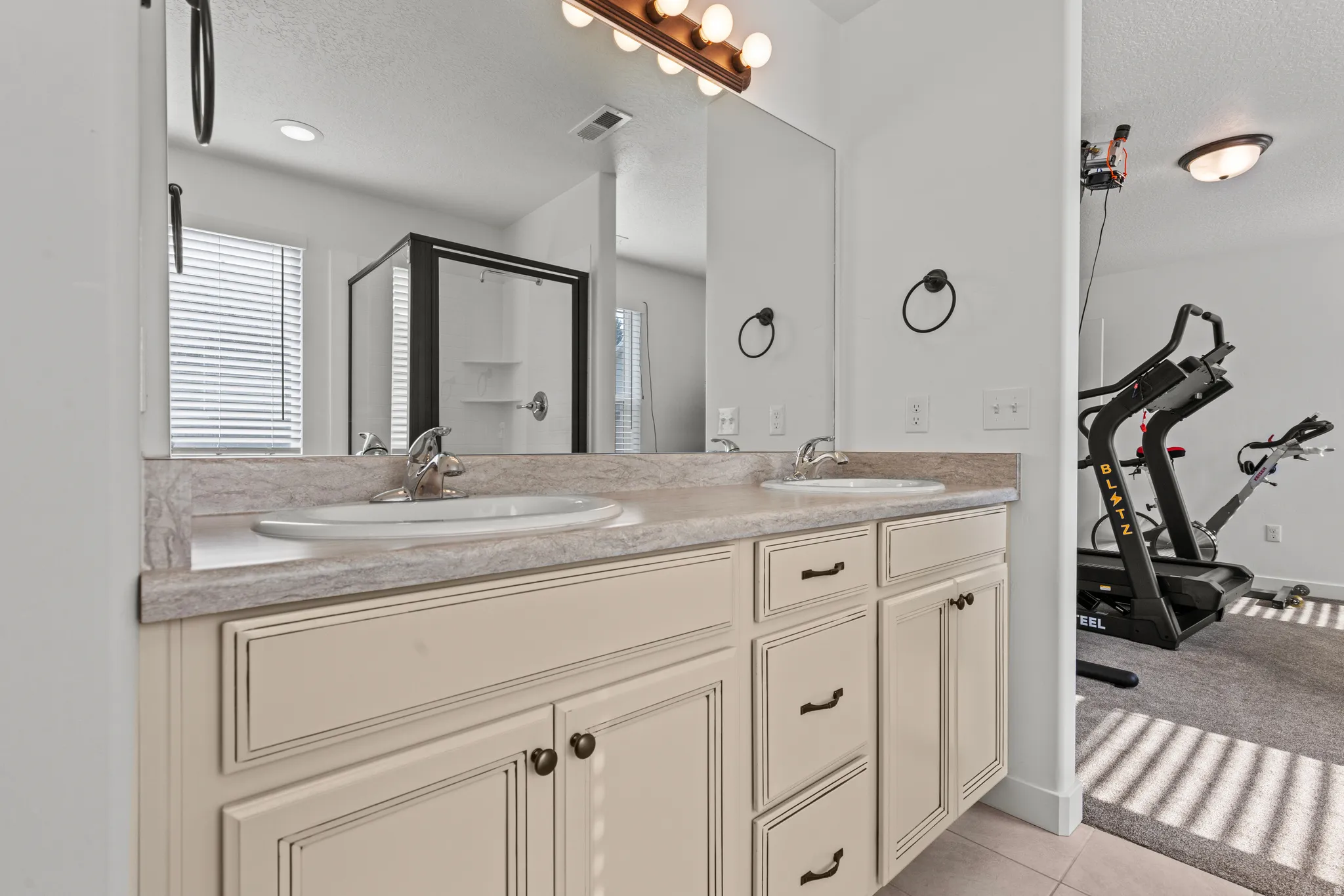 Dual vanity with light-toned cabinetry and a patterned countertop