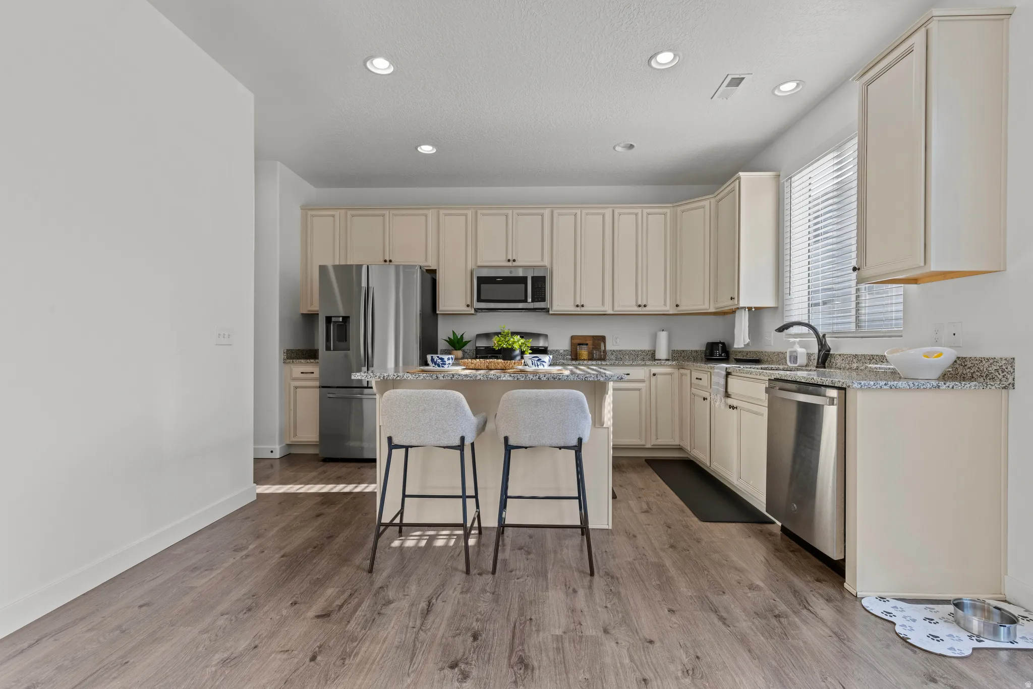 Kitchen featuring wood-finish flooring, recessed lighting, and light-toned cabinetry