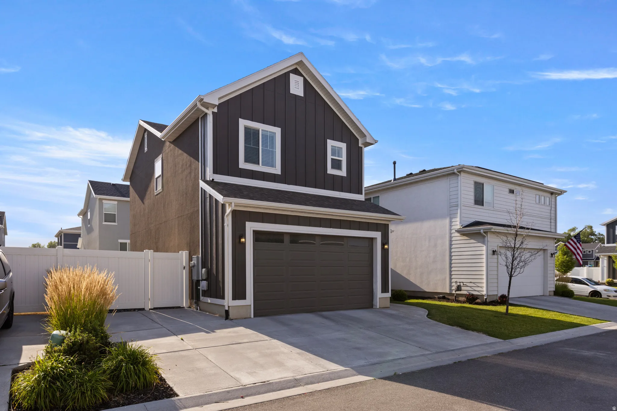 Contemporary two-story residence featuring a dark gray vertical and horizontal siding facade with white trim