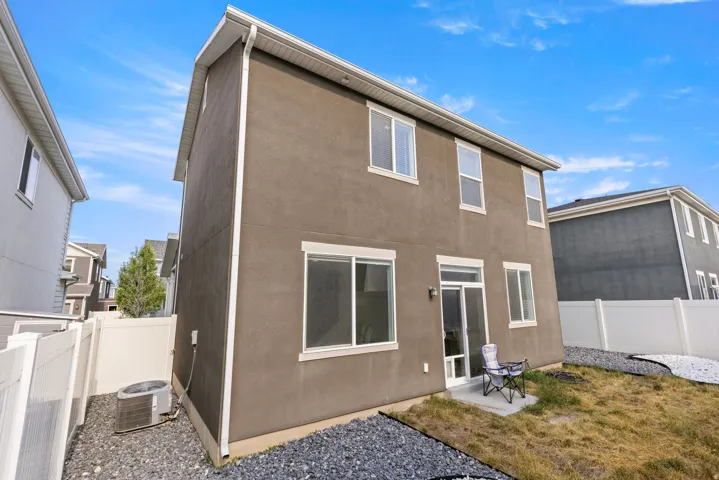 Two-story stucco exterior with white trim and multiple windows