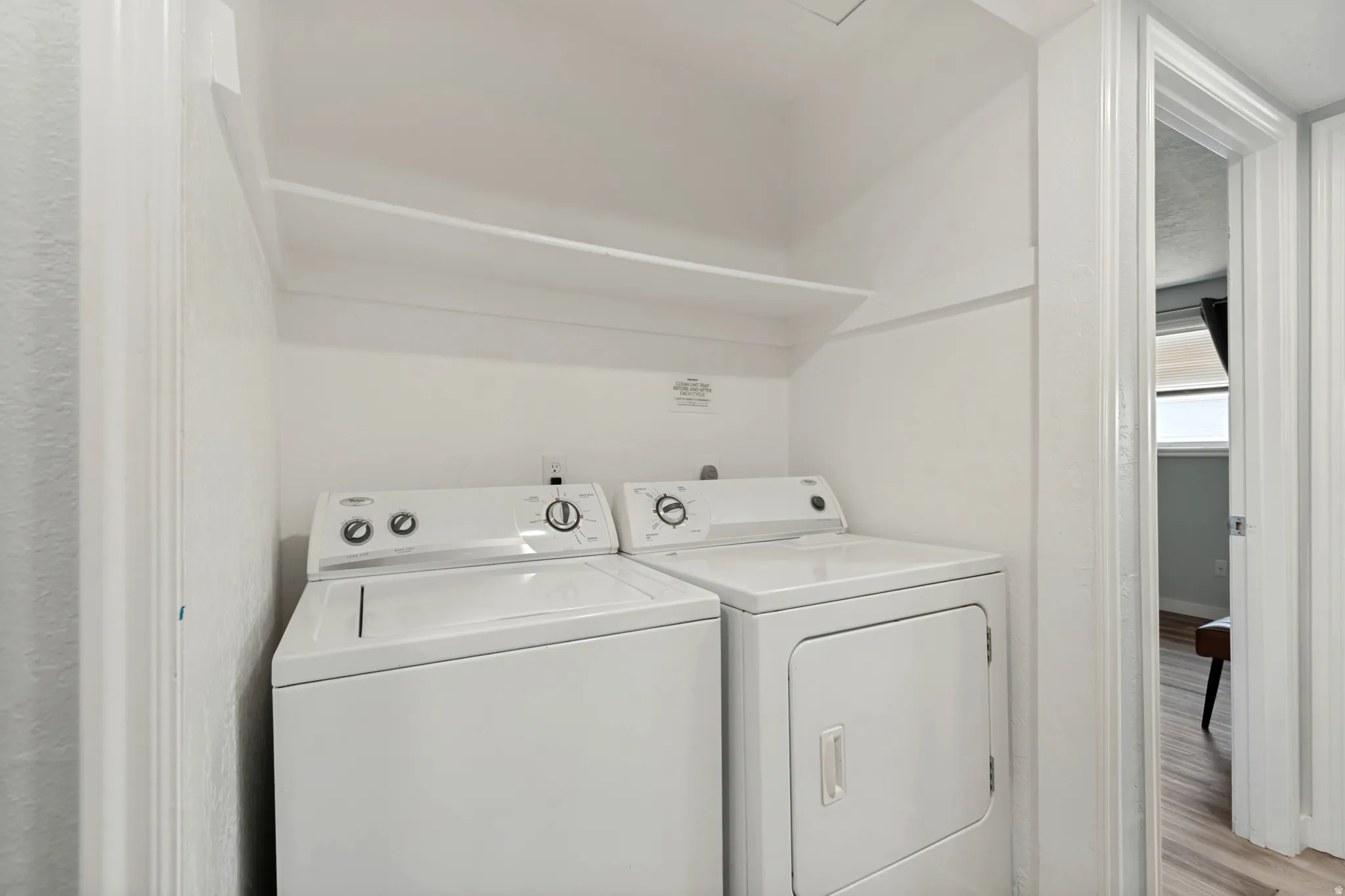 Dedicated laundry area featuring a built-in shelf and white walls