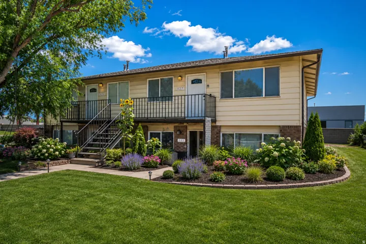 Two-story property featuring a central staircase, private balconies, and ground-level patios