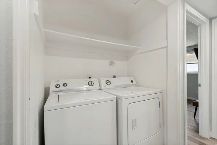 Dedicated laundry area featuring a built-in shelf and white walls