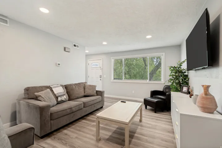 Living area featuring wood-finish flooring, recessed lighting, and light gray wall tones