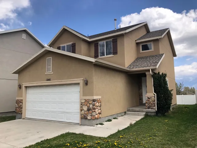 Two-story stucco residence featuring a two-car garage with a panel door