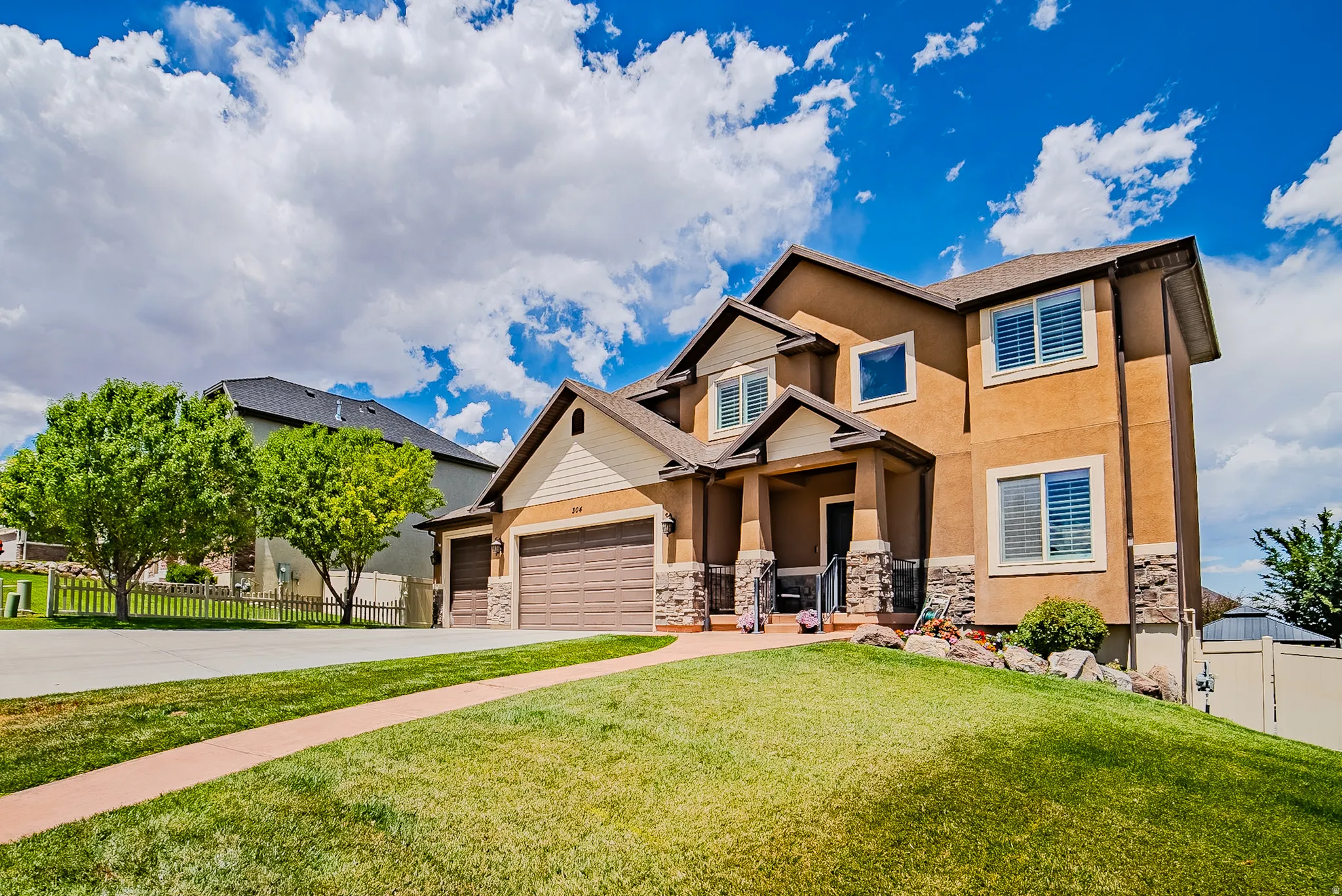 Contemporary two-story residence featuring a stucco exterior with stone accents and a covered front entry