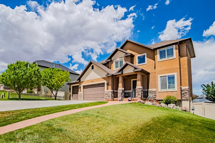 Contemporary two-story residence featuring a stucco exterior with stone accents and a covered front entry