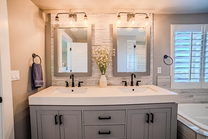 Dual vanity featuring under-mount sinks, matte black fixtures, and a light-toned countertop
