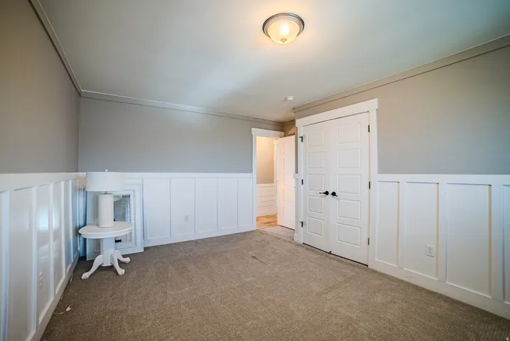 Neutral-toned carpeting paired with white wainscoting and light gray walls