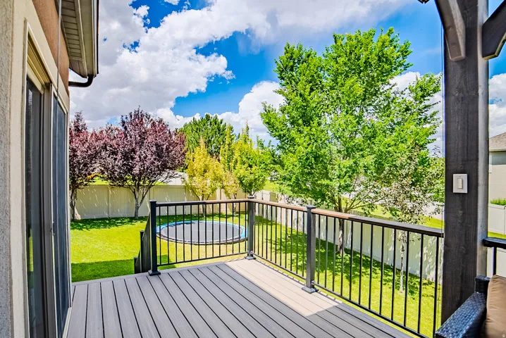 Expansive outdoor deck featuring wood-finish composite decking and dark metal railings with a wood-finish top rail