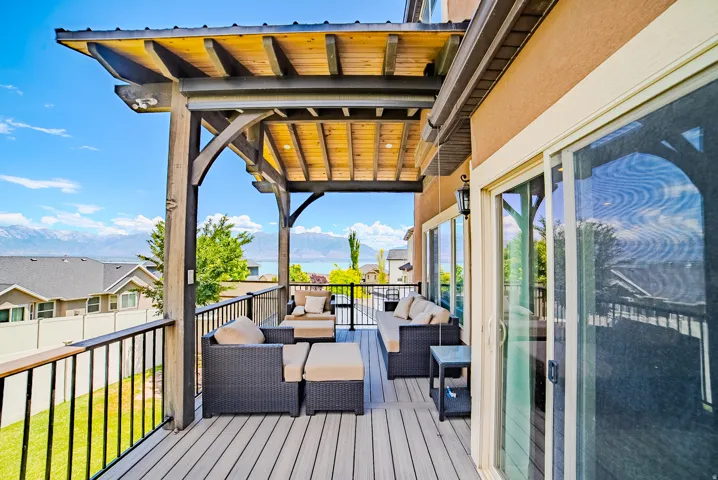 Spacious outdoor deck featuring composite decking, a pergola with wood ceiling, and metal railings