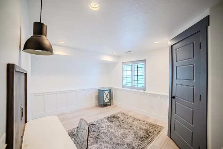 Room featuring light wood-finish flooring, white wainscoting, and recessed lighting