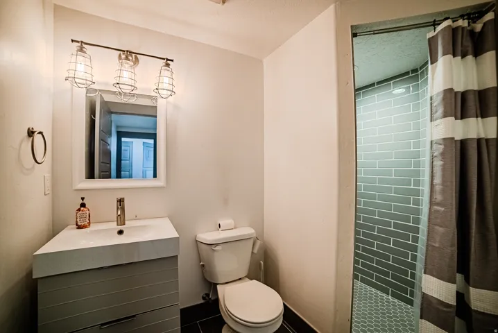 Bathroom featuring a modern vanity with integrated sink, brushed nickel faucet, and a contemporary mirror