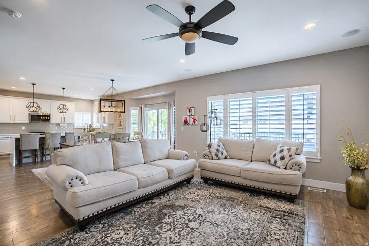 Open-concept living area featuring wood-finish flooring, recessed lighting, and a ceiling fan