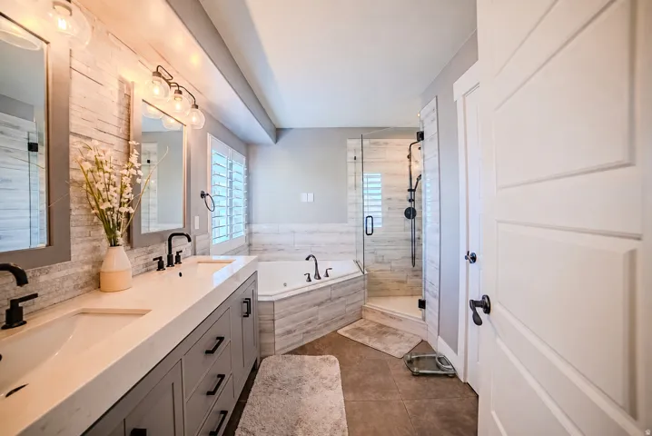 Bathroom featuring a double vanity with stone countertops and gray cabinetry