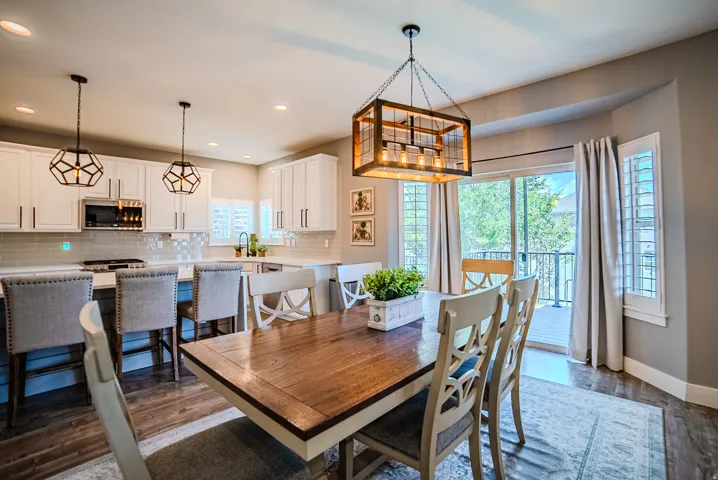 Open-concept dining area featuring wood-finish flooring and a contemporary chandelier