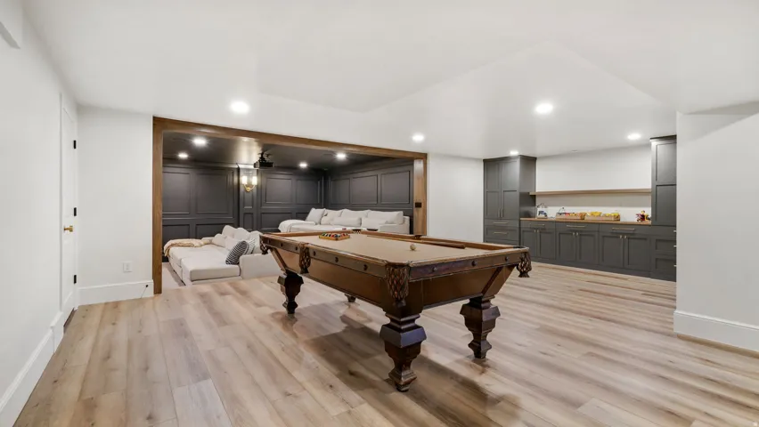 Spacious recreation area featuring light wood-finish flooring