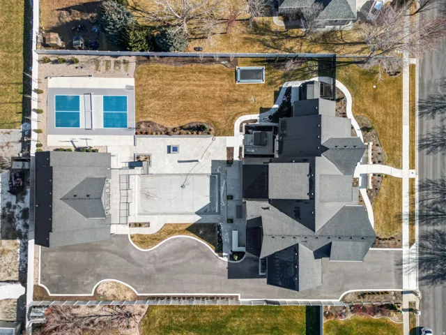 Expansive property featuring a multi-gabled roofline, asphalt driveway, and extensive hardscaping