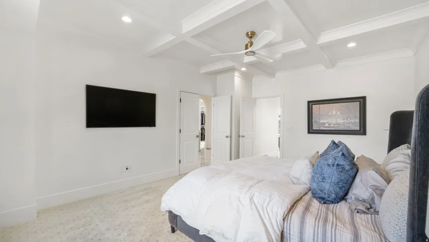 Spacious room featuring coffered ceilings, recessed lighting, and a ceiling fan with brushed gold accents