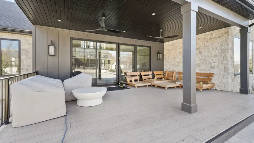 Spacious covered deck featuring plank-style flooring, a dark paneled ceiling, and recessed lighting