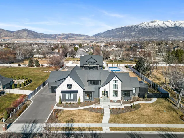Contemporary residence featuring a multi-gabled roofline and a blend of stone and dark siding