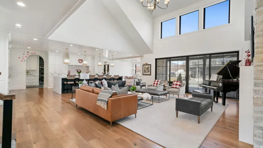 Vaulted great room featuring hardwood flooring and a stone accent wall