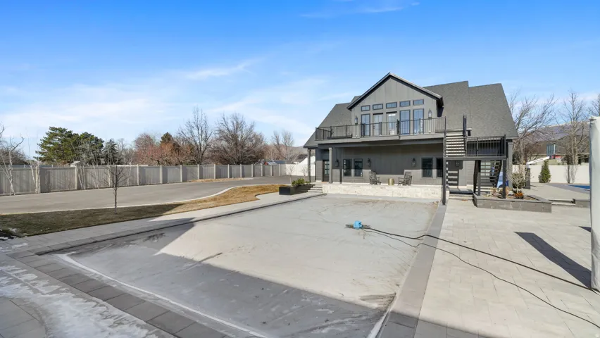 Contemporary gray siding residence featuring a spacious upper-level balcony with black railings