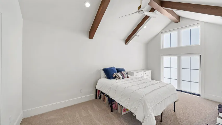 Vaulted ceiling featuring exposed wood beams and recessed lighting