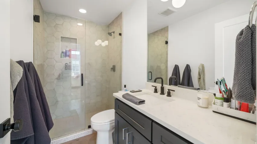 Bathroom vanity with a white countertop and dark cabinetry