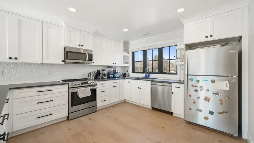 White shaker cabinetry paired with dark countertops and stainless steel appliances