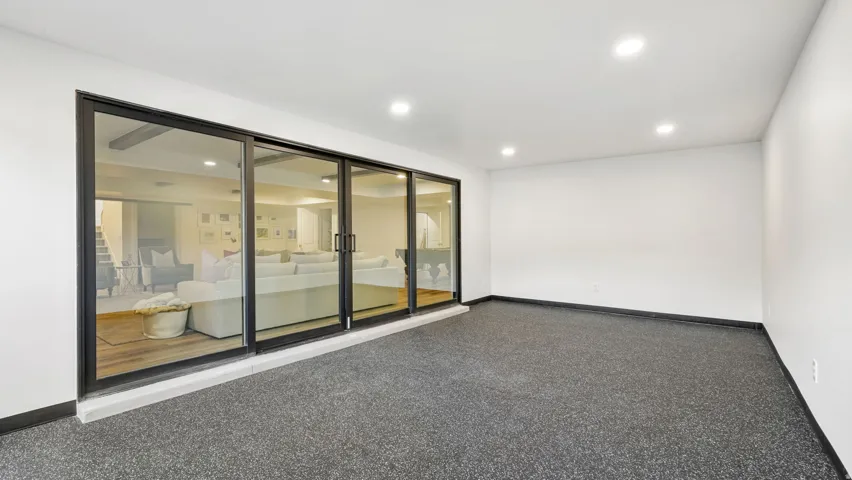 Spacious room featuring dark speckled flooring and recessed lighting