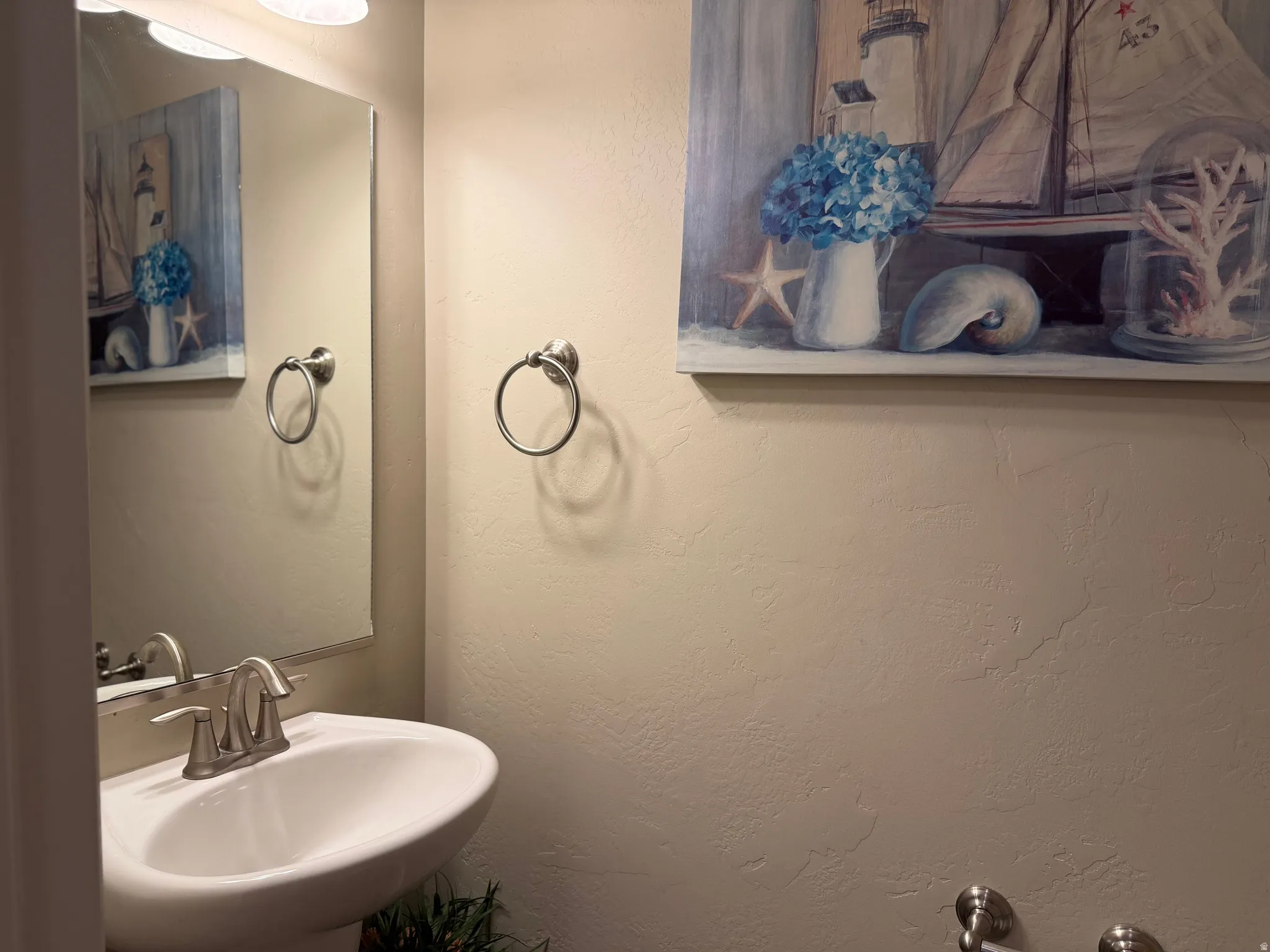 Half bath, Pedestal sink with a brushed nickel faucet and coordinating towel ring
