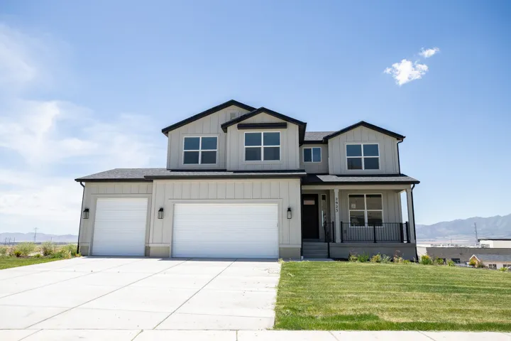 A farmhouse two-story featuring a large covered front porch.